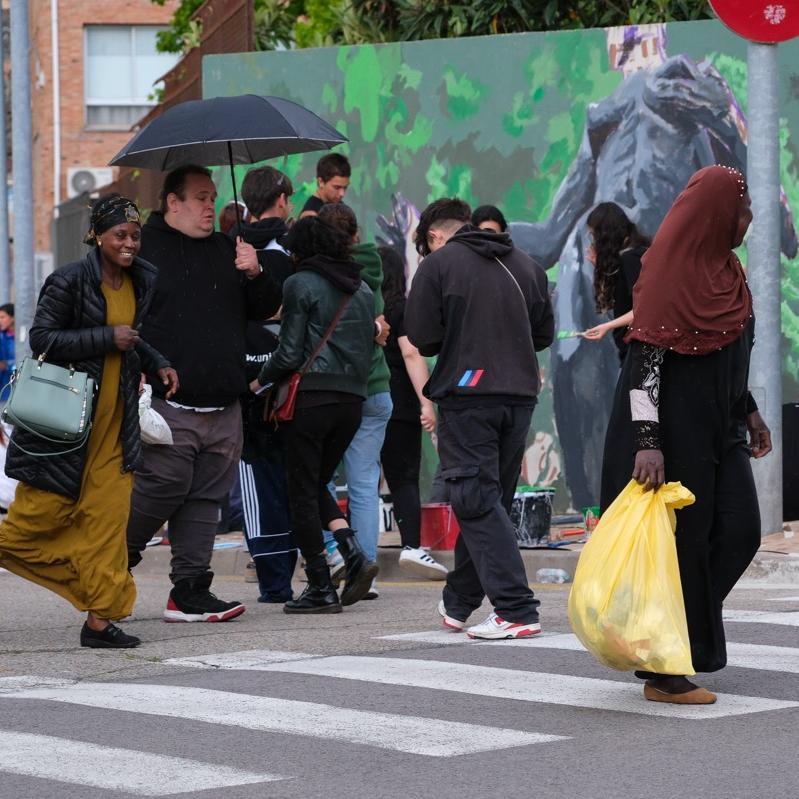 Persones passant davant el mural